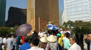 Côn an thường phục “cầm dù” che đi các biểu ngữ tưởng niệm liệt sĩ chiến tranh biên giới Việt – Trung 1979 ngày 17/2/2016 tại SG. Ảnh: Facebook